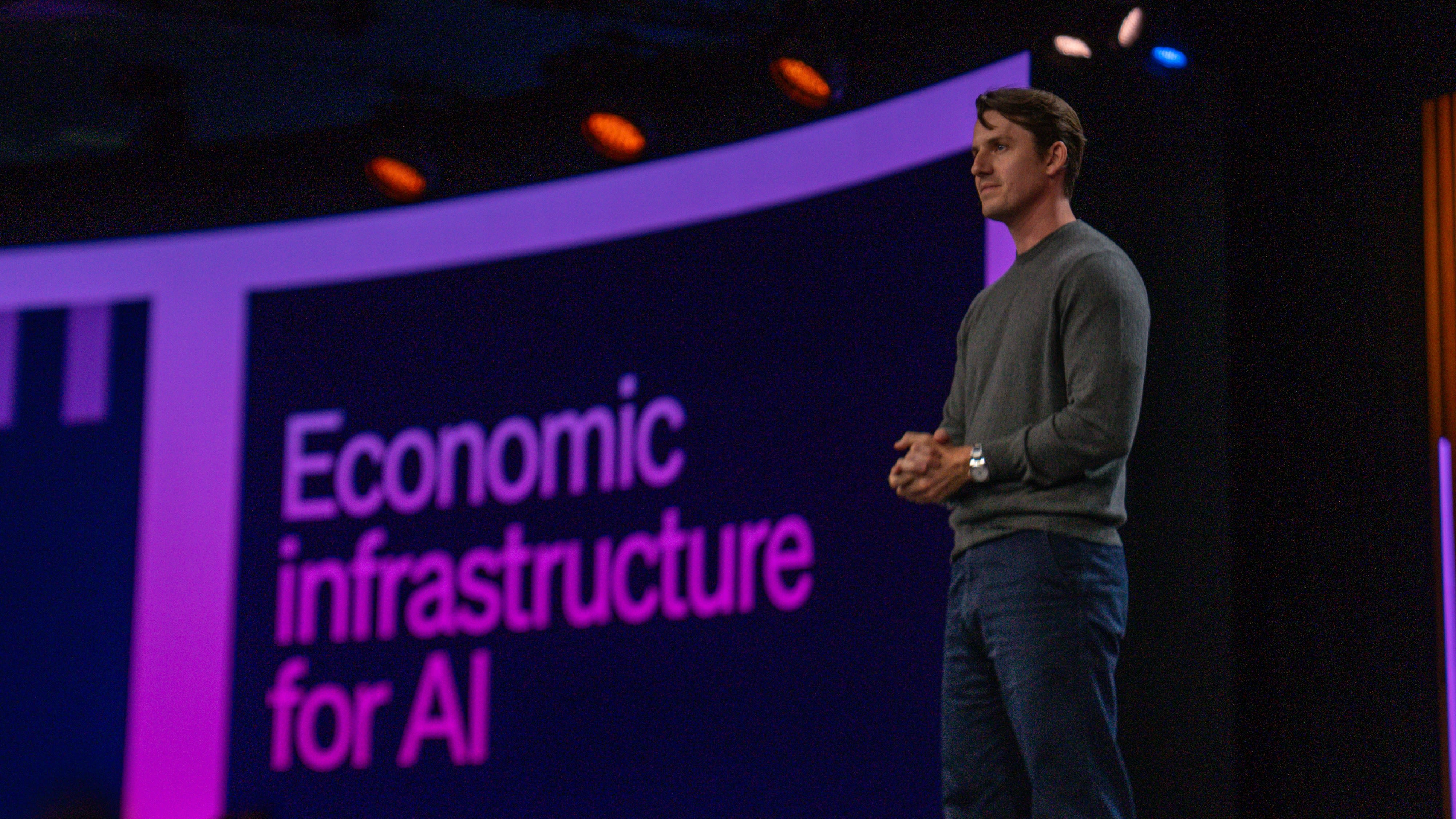 Speaker on stage at Stripe Sessions 2026 with the words Economic infrastructure for AI displayed behind him