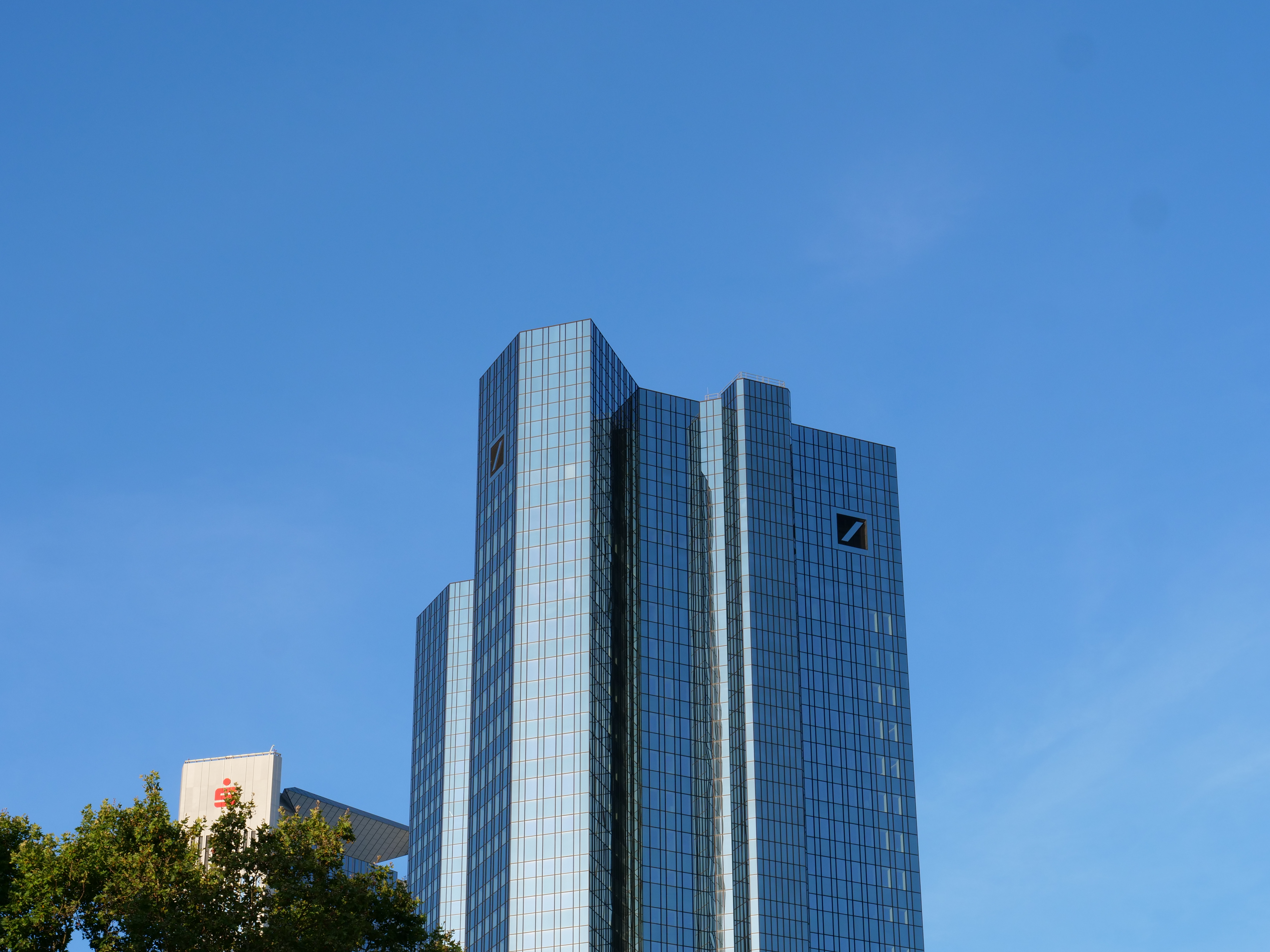 Deutsche Bank's Frankfurt headquarters viewed from Opernplatz under a clear blue sky in 2019.