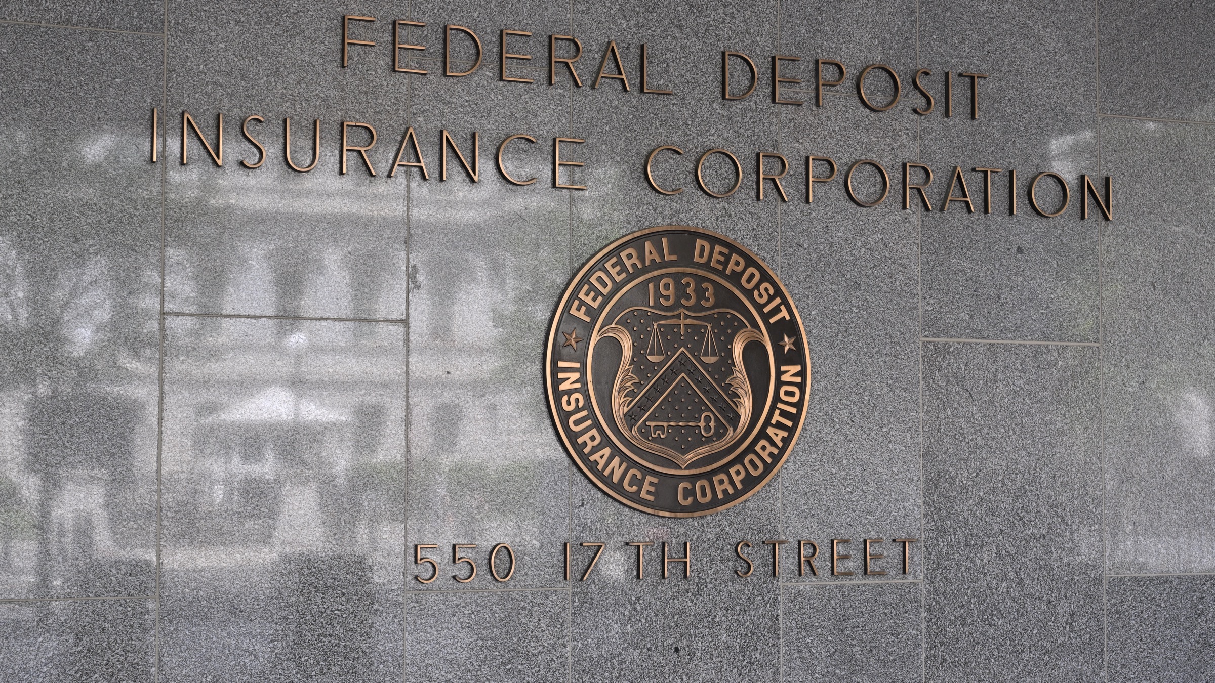 The bronze lettering and seal of the Federal Deposit Insurance Corporation on the granite facade of its Washington headquarters at 550 17th Street.