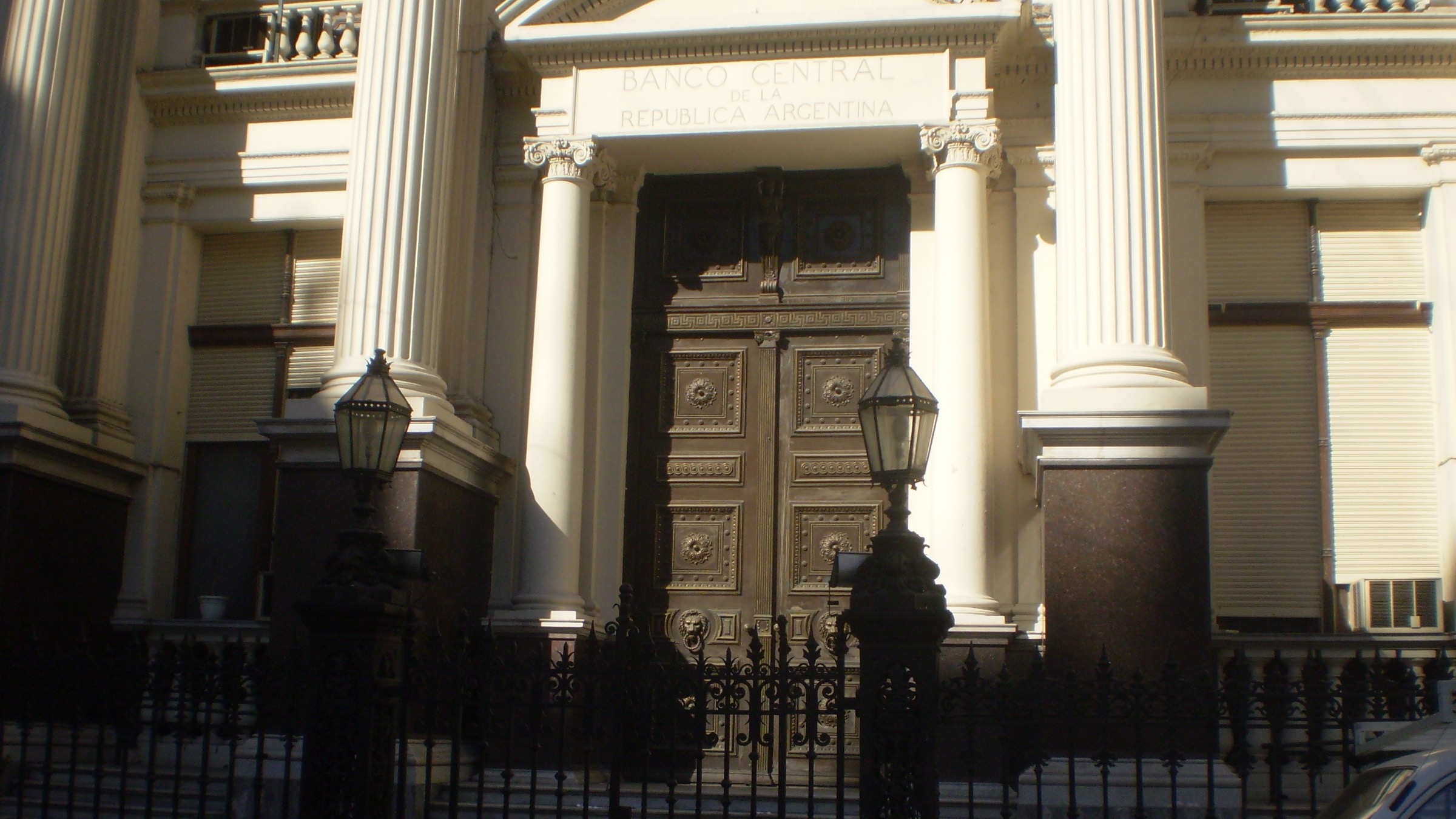Carved wooden doors beneath the inscription Banco Central de la Republica Argentina, behind an iron fence
