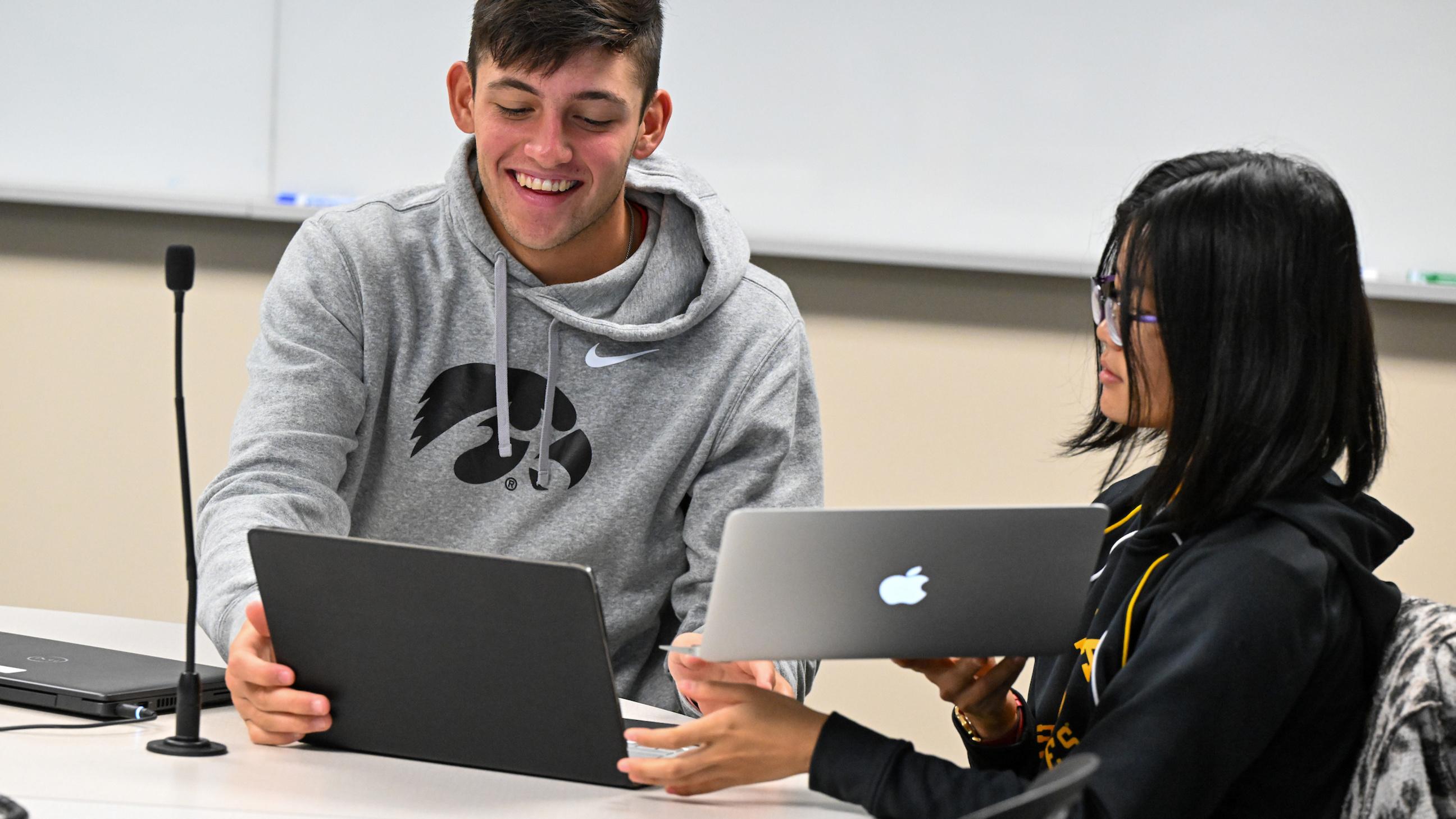 University of Iowa students using laptops during an AI-related workshop, illustrating guidance on responsible AI tool use in academic research.