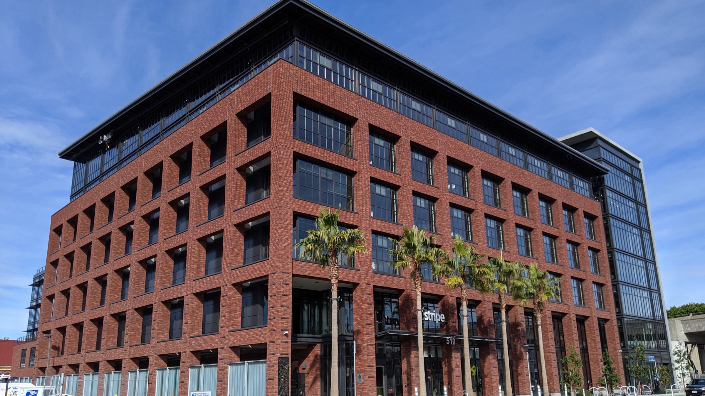 Stripe’s former red-brick headquarters building at 510 Townsend Street in San Francisco, with the Stripe name above the entrance and palm trees in front